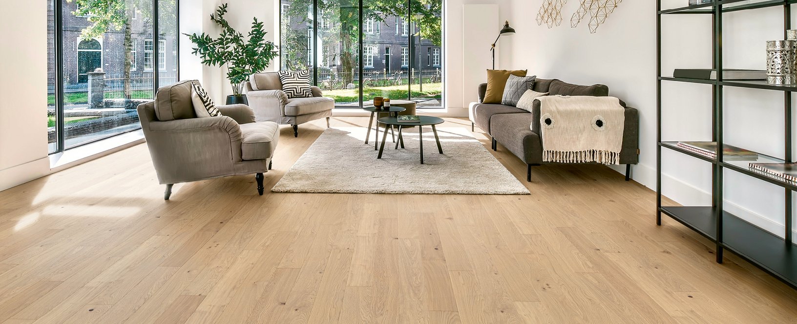 Parkett Landhausdiele Eiche Natur Nebla Geräumiges Wohnzimmer mit hellem Eichenparkett, modernen Möbeln, großer Fensterfront und Industriedeko.