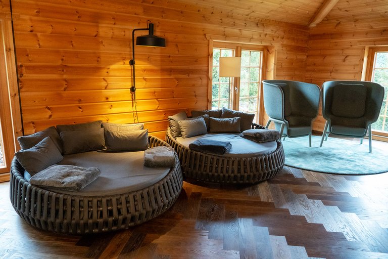 Round, comfortable loungers in a relaxation room with lots of wood and a herringbone parquet floor