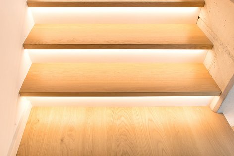 Detailansicht einer Holztreppe mit integrierter LED-Beleuchtung