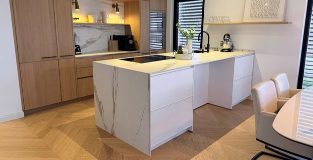 Chevron flooring oak Natur Perla Modern kitchen with French herringbone oak parquet flooring, white marble kitchen island, and oak cabinets.