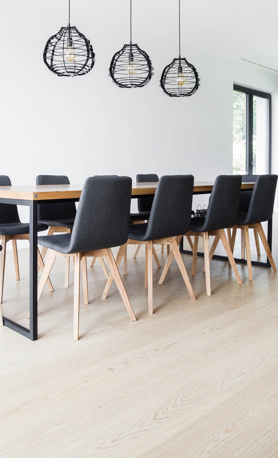 Dining room with white oiled country house floorboards and dark furniture