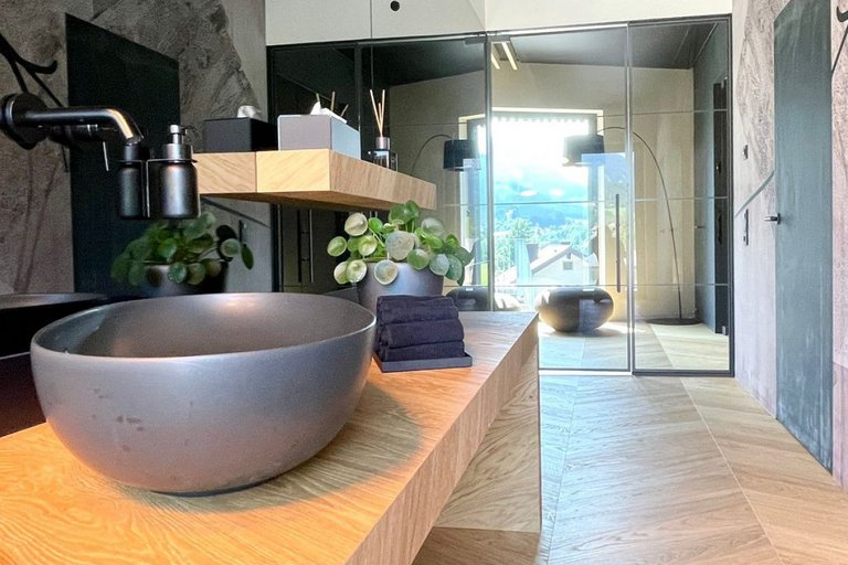 Wooden washbasin with countertop washbasin in a bathroom with parquet flooring